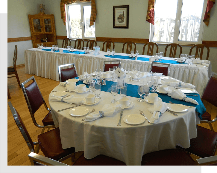 A round table with white tablecloth and blue napkins.